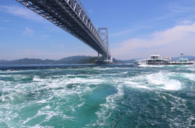 鳴門漩渦與大鳴門橋觀潮船靠近翻捲的漩渦，兵庫縣淡路島