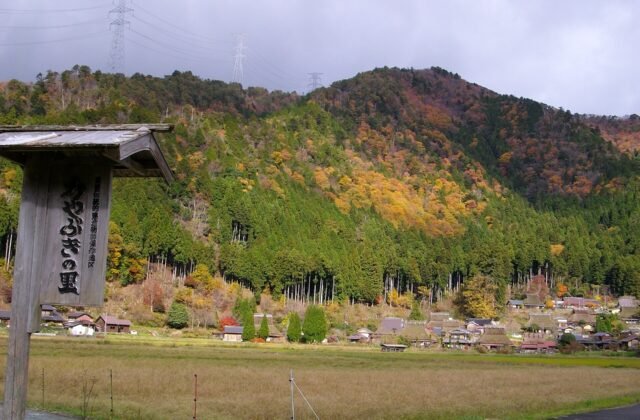 美山かやぶきの里山腳下的茅葺屋頂民家聚落與秋色山巒