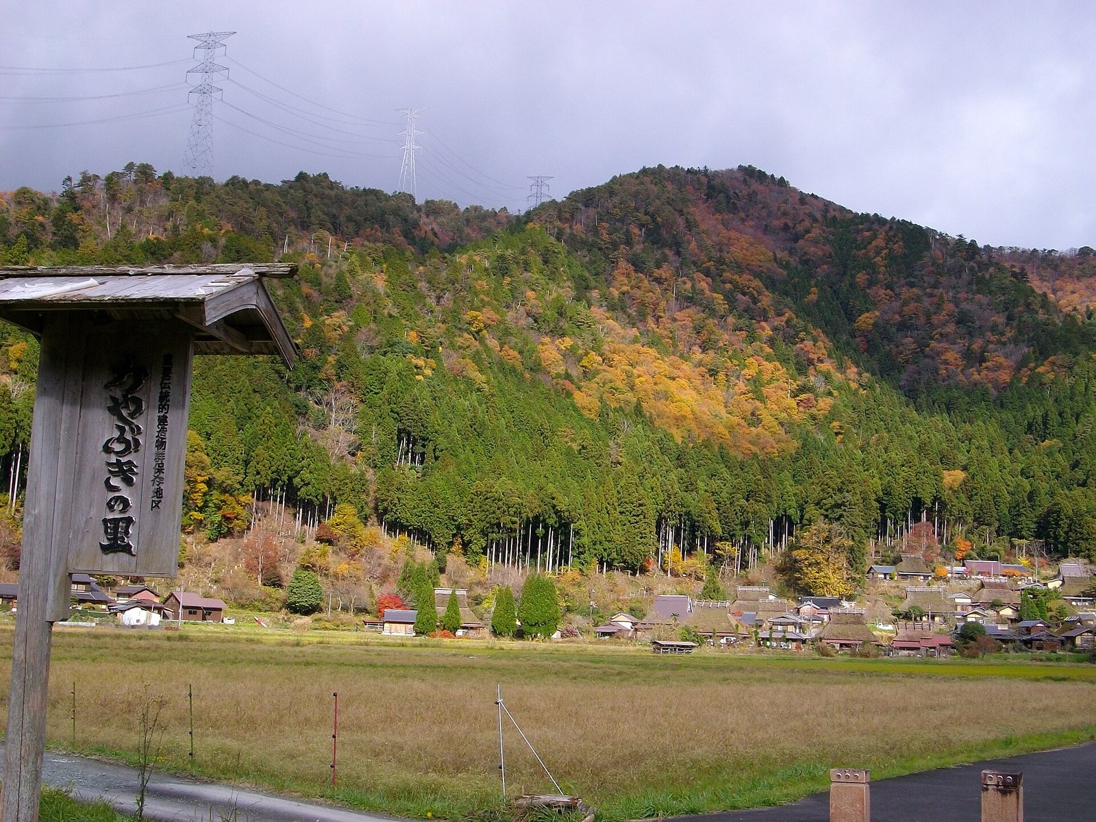 美山かやぶきの里山腳下的茅葺屋頂民家聚落與秋色山巒