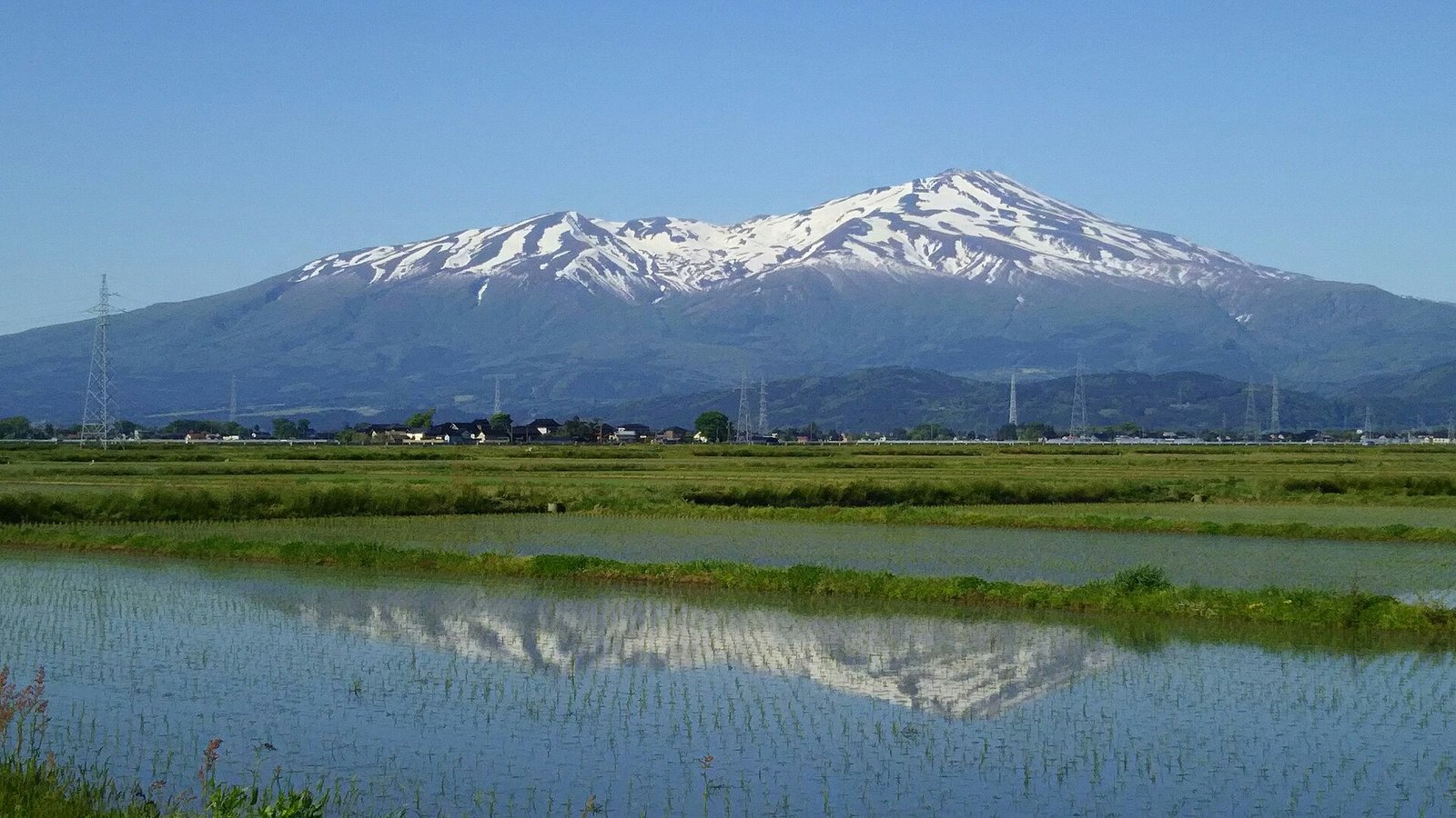 殘雪覆蓋的鳥海山，倒映在庄內平野的水田上