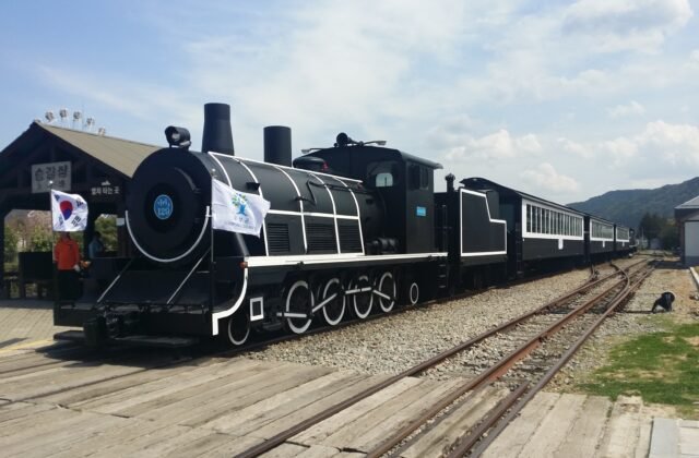谷城섬진강火車村黑色復刻蒸汽火車停在鐵軌上遠方群山