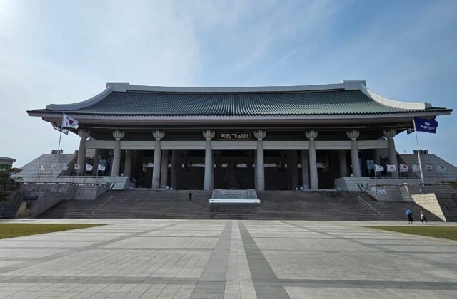 天安獨立紀念館的象徵建築「겨레의 집」，一座巨大的傳統瓦頂殿堂，前方是寬闊的廣場