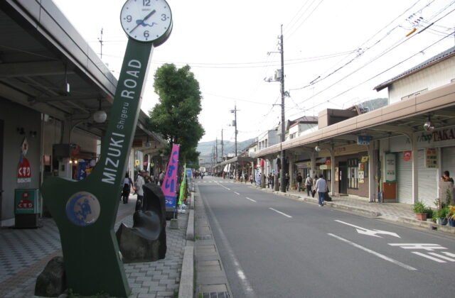 境港水木茂之路的昭和風商店街，立著寫有 MIZUKI ROAD 的綠色時鐘標誌