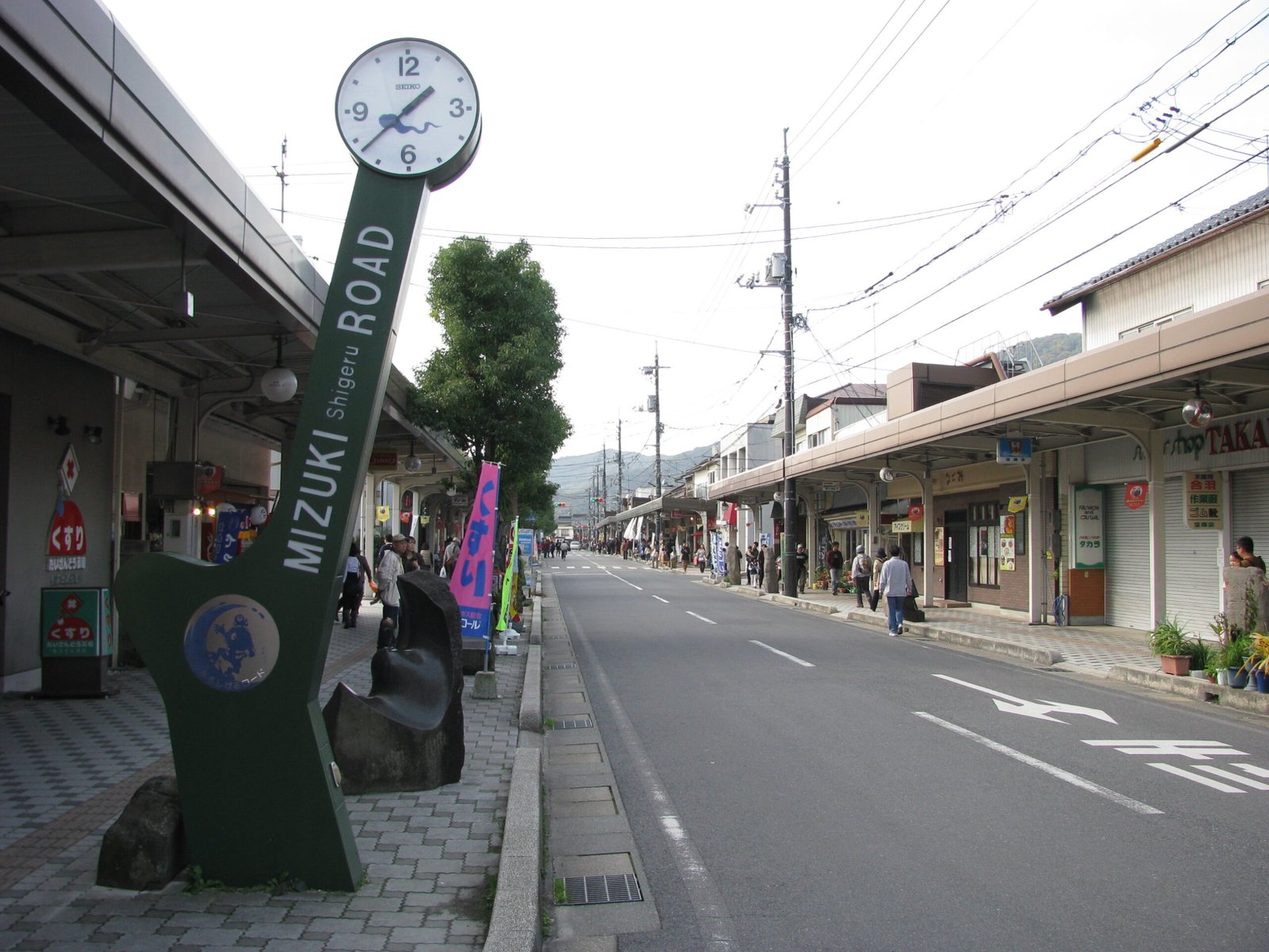 境港水木茂之路的昭和風商店街，立著寫有 MIZUKI ROAD 的綠色時鐘標誌