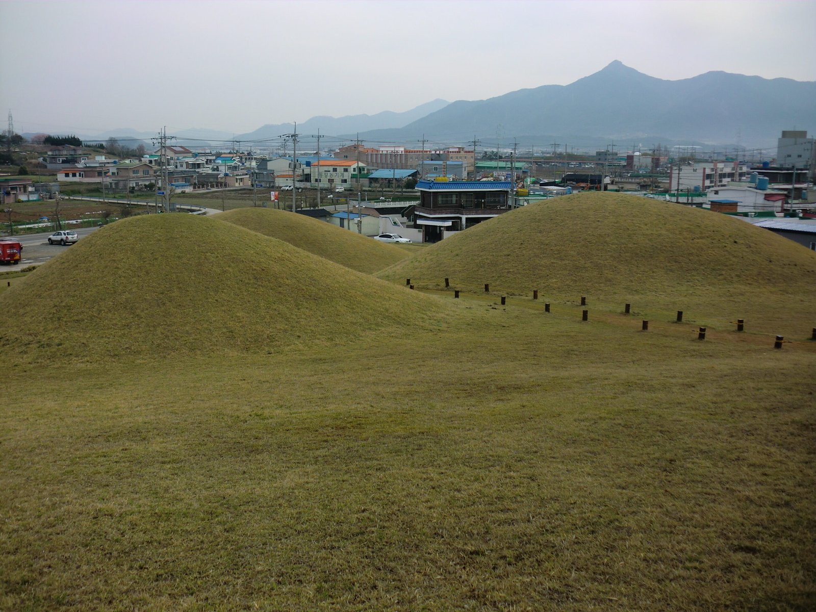 固城松鶴洞古墳群，草覆的小伽倻王陵級封土墳，遠方是市區與山