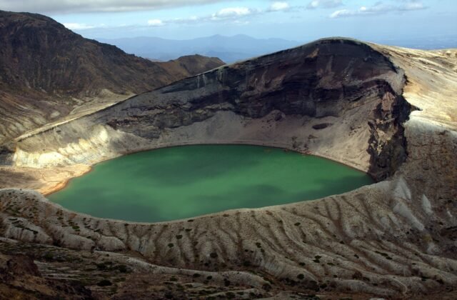 藏王御釜火口湖的翡翠綠湖面與火山岩壁