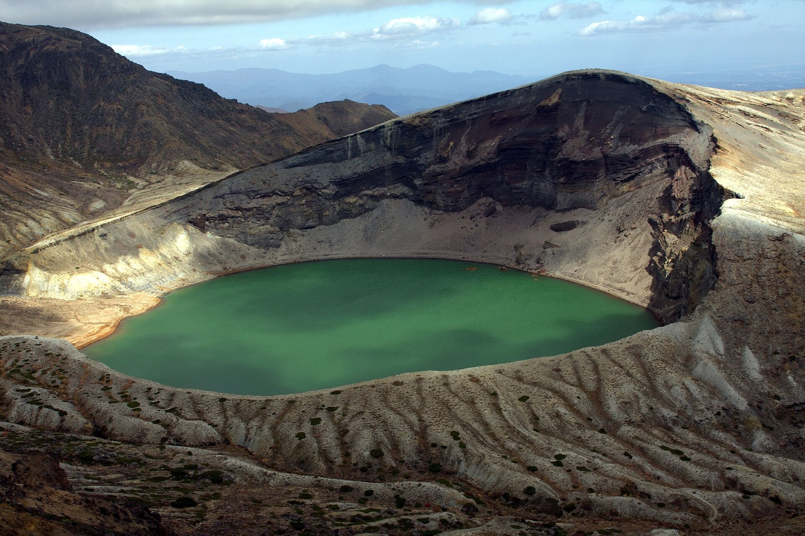 藏王御釜火口湖的翡翠綠湖面與火山岩壁