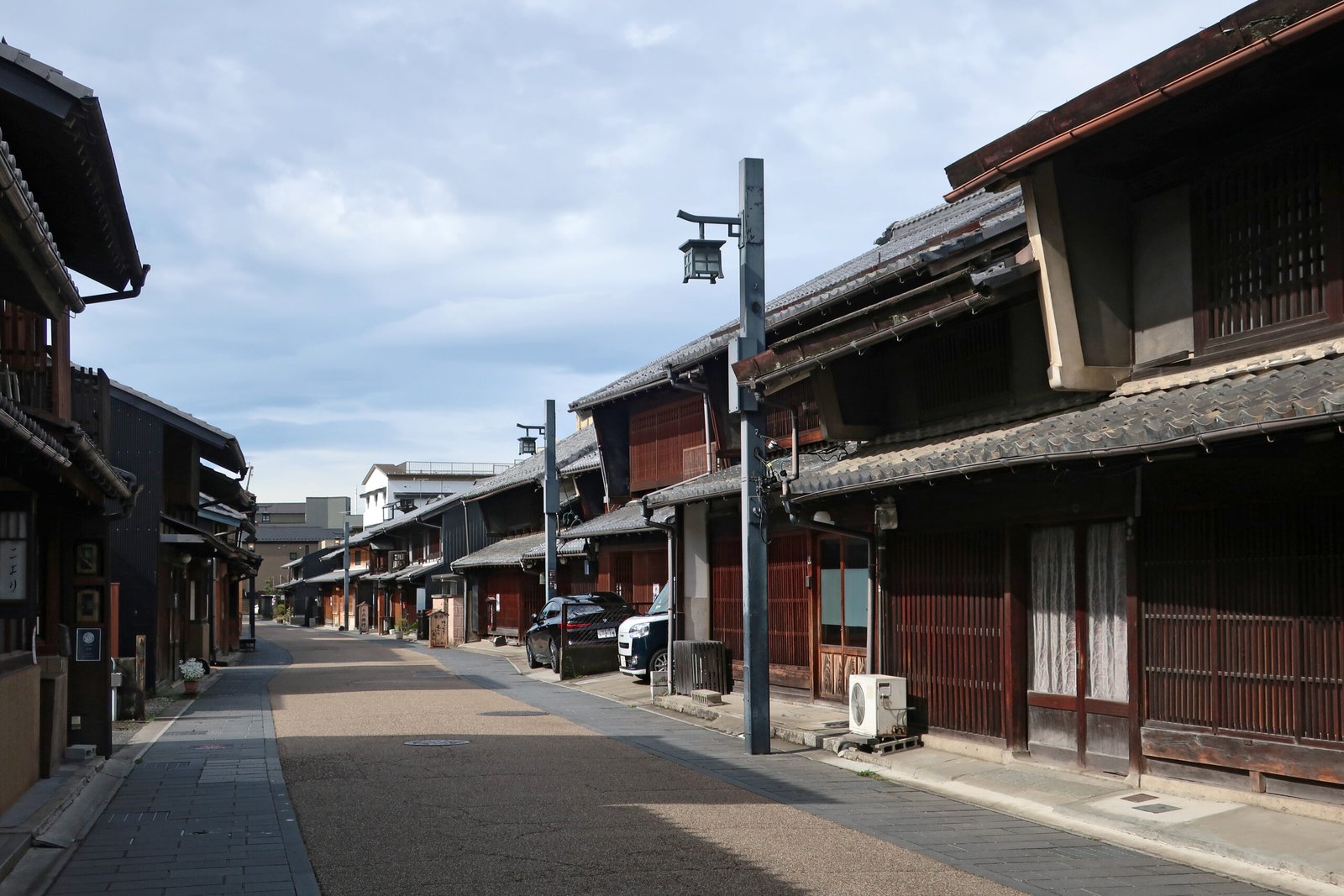 岐阜川原町老街，兩側是格子窗與深色木造町家，遠處延伸到長良川方向