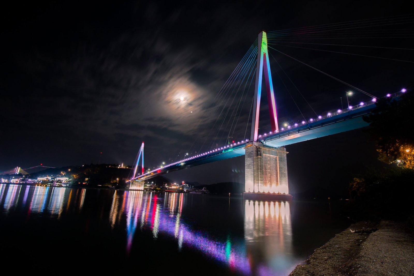 麗水突山大橋夜間彩色燈光倒映在海面上的景色